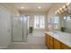 Bright bathroom featuring a soaking tub, separate shower, and dual sink vanity with wooden cabinetry at 15134 W Waterford Dr, Surprise, AZ 85374