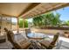 Inviting covered patio with a round glass table and cushioned chairs, creating a cozy outdoor dining and lounging area at 15134 W Waterford Dr, Surprise, AZ 85374