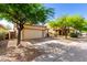 Single-story home featuring a desert landscape, two-car garage and mature trees at 152 N 194Th Ln, Buckeye, AZ 85326