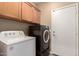 Functional laundry room featuring a full-size washer and dryer set, with wooden cabinets above at 152 N 194Th Ln, Buckeye, AZ 85326