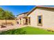 Back patio with bench, grill, artificial turf, and tan stucco wall, providing a relaxing outdoor space at 152 N 194Th Ln, Buckeye, AZ 85326