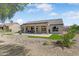 A home's backyard featuring artificial turf, desert landscaping, and shade trees at 15766 W Grand Point Ln, Surprise, AZ 85374