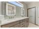Bathroom with dual sinks, illuminated mirrors and modern cabinetry at 15766 W Grand Point Ln, Surprise, AZ 85374