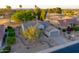 Charming single-story home with desert landscaping, neutral paint, mature trees, and attached two-car garage at 15766 W Grand Point Ln, Surprise, AZ 85374