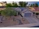 Charming single-story home with desert landscaping, neutral paint, mature trees, and attached two-car garage at 15766 W Grand Point Ln, Surprise, AZ 85374