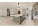Bright and open kitchen with a large island, stainless steel appliances and tile flooring at 15766 W Grand Point Ln, Surprise, AZ 85374