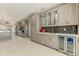 Open kitchen design with gray cabinets, black subway tile backsplash, wine fridge and stainless steel appliances at 15766 W Grand Point Ln, Surprise, AZ 85374
