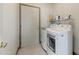Laundry room featuring a modern washer and dryer set with storage shelf at 15766 W Grand Point Ln, Surprise, AZ 85374
