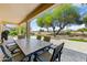 Covered patio with outdoor dining area overlooking landscaped backyard at 15766 W Grand Point Ln, Surprise, AZ 85374
