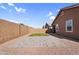 Enclosed backyard featuring block wall fencing, artificial turf and a large paver area at 16396 W Questa Dr, Surprise, AZ 85387
