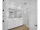 Bright primary bathroom features double vanity, large mirror, and tiled walk-in shower at 16396 W Questa Dr, Surprise, AZ 85387