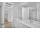 This is a bright bathroom with double sinks, a large mirror, and tile floor at 16396 W Questa Dr, Surprise, AZ 85387