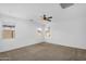 This carpeted bedroom has a ceiling fan and two windows for natural light at 16396 W Questa Dr, Surprise, AZ 85387