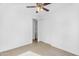 This carpeted bedroom has a ceiling fan and a door to the en suite bathroom at 16396 W Questa Dr, Surprise, AZ 85387