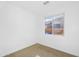 This simple bedroom has neutral carpet, a window with blinds and white walls at 16396 W Questa Dr, Surprise, AZ 85387
