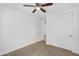 This is a bright bedroom with neutral carpet, closet with sliding doors, and a ceiling fan at 16396 W Questa Dr, Surprise, AZ 85387