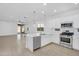 Modern kitchen featuring white cabinets, stainless steel appliances, and a center island with a sink at 16396 W Questa Dr, Surprise, AZ 85387