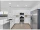 Well-lit kitchen features stainless steel appliances, white cabinets and tiled floor at 16396 W Questa Dr, Surprise, AZ 85387