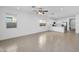 Bright and airy living room with tile flooring, ceiling fan, and views of the kitchen and backyard at 16396 W Questa Dr, Surprise, AZ 85387