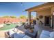Inviting backyard with a sparkling pool and comfortable patio seating for relaxing and entertaining outdoors at 16924 W Stevenage St, Surprise, AZ 85374
