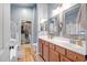 Spacious bathroom with double sinks, wood-look floors, and a walk-in closet, providing both style and functionality at 16924 W Stevenage St, Surprise, AZ 85374