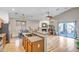 Open-concept kitchen flows into the living area, with wood-look floors and a cozy fireplace creating a warm ambiance at 16924 W Stevenage St, Surprise, AZ 85374