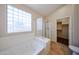 Bathroom featuring a glass block window, walk-in shower, and a soaking tub at 17050 W Manchester Dr, Surprise, AZ 85374
