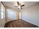 Bright bedroom featuring wood-look floors, ceiling fan, closet and a door to an adjoining bathroom at 17050 W Manchester Dr, Surprise, AZ 85374