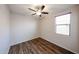 This bedroom has a ceiling fan, a window providing natural light, and wood-look floors at 17050 W Manchester Dr, Surprise, AZ 85374