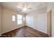 This bedroom has a ceiling fan, wood-look floors, windows, and a closet at 17050 W Manchester Dr, Surprise, AZ 85374
