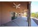 This covered patio has curtains, a ceiling fan and a view of the yard at 17050 W Manchester Dr, Surprise, AZ 85374
