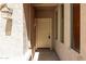 Well lit covered entry with sidelight window, lantern fixture and beige door at 17050 W Manchester Dr, Surprise, AZ 85374