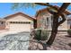 Inviting front exterior showcasing a two-car garage and desert landscaping features at 17050 W Manchester Dr, Surprise, AZ 85374