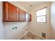 Laundry room with upper cabinets and a window at 17050 W Manchester Dr, Surprise, AZ 85374
