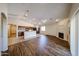 Open-concept living room with hardwood floors, ceiling fan, and a cozy fireplace at 17050 W Manchester Dr, Surprise, AZ 85374
