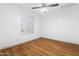This bedroom features hardwood floors, a ceiling fan, and a window with white blinds at 18629 N 10Th Ave, Phoenix, AZ 85027