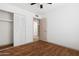 This bedroom features wood flooring, a ceiling fan, and closet with folding doors at 18629 N 10Th Ave, Phoenix, AZ 85027