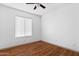 This bedroom features wood flooring, a ceiling fan, and a window with white blinds at 18629 N 10Th Ave, Phoenix, AZ 85027