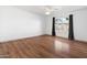 Bright bedroom featuring hardwood floors, a ceiling fan, and large window with black curtains at 18629 N 10Th Ave, Phoenix, AZ 85027