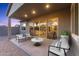 Inviting covered back patio with stylish furniture and seamless indoor-outdoor flow through sliding glass doors at 19231 W Missouri Ave, Litchfield Park, AZ 85340