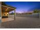 Expansive backyard features a covered patio, perfect for outdoor relaxation and entertaining at dusk at 19231 W Missouri Ave, Litchfield Park, AZ 85340