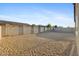 View of the backyard showcasing a gravel area enclosed by a tall block wall fence offering privacy and space at 19231 W Missouri Ave, Litchfield Park, AZ 85340