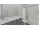 Bright bathroom featuring a shower-tub combo, white tile, gray vanity, and a large mirror reflecting the space at 19231 W Missouri Ave, Litchfield Park, AZ 85340