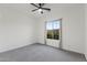 Neutral bedroom with a large window offering lots of light, ceiling fan, and carpet, creating a comfy atmosphere at 19231 W Missouri Ave, Litchfield Park, AZ 85340
