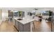 Spacious kitchen island with seating, flowing into the living room and dining area with an open concept design at 19231 W Missouri Ave, Litchfield Park, AZ 85340