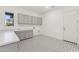 Spacious laundry room with gray cabinets, sink, and modern tile flooring, offering style and functionality at 19231 W Missouri Ave, Litchfield Park, AZ 85340