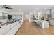 Bright, open living area with herringbone wood floors, a modern ceiling fan and light gray kitchen at 19231 W Missouri Ave, Litchfield Park, AZ 85340
