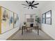 Bright home office with a ceiling fan, large artwork, and a window to allow ample natural light in the room at 19231 W Missouri Ave, Litchfield Park, AZ 85340
