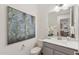 Charming powder room features white and gray color scheme and decorative artwork adding to the room's appeal at 19231 W Missouri Ave, Litchfield Park, AZ 85340