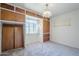 Bright bedroom featuring wooden storage cabinets, neutral carpet, and a decorative ceiling light at 1945 E Solano Dr, Phoenix, AZ 85016